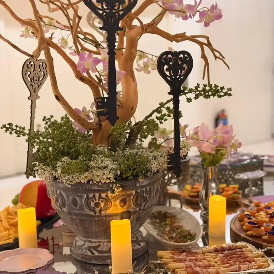 Centro de mesa con llaves decorativas, rama seca y orquídeas